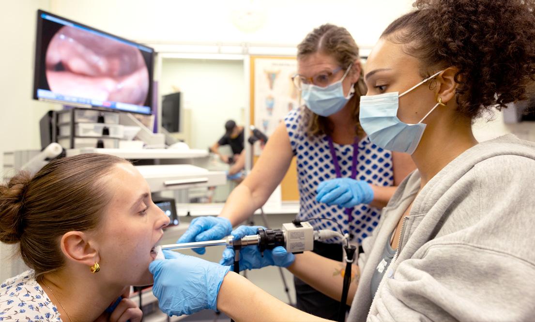 Two clinicians assist a patient during a vocal examination
